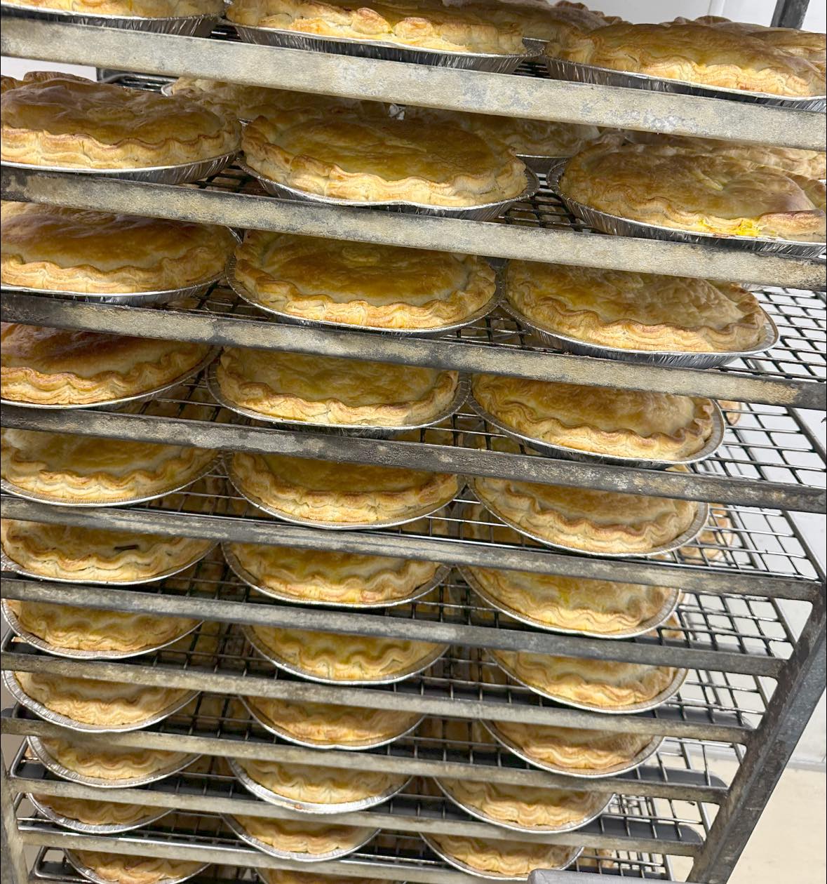 Freshly baked Mal's pies on a rack
